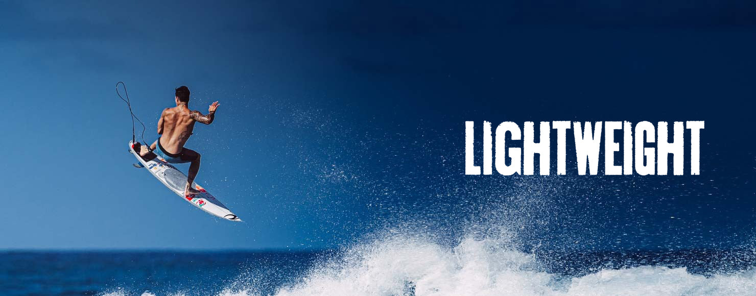 Surfer performing a trick on a wave with 'LIGHTWEIGHT' text in the background