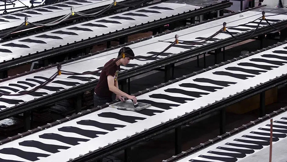 Person working on a large metal structure with white and black patterns