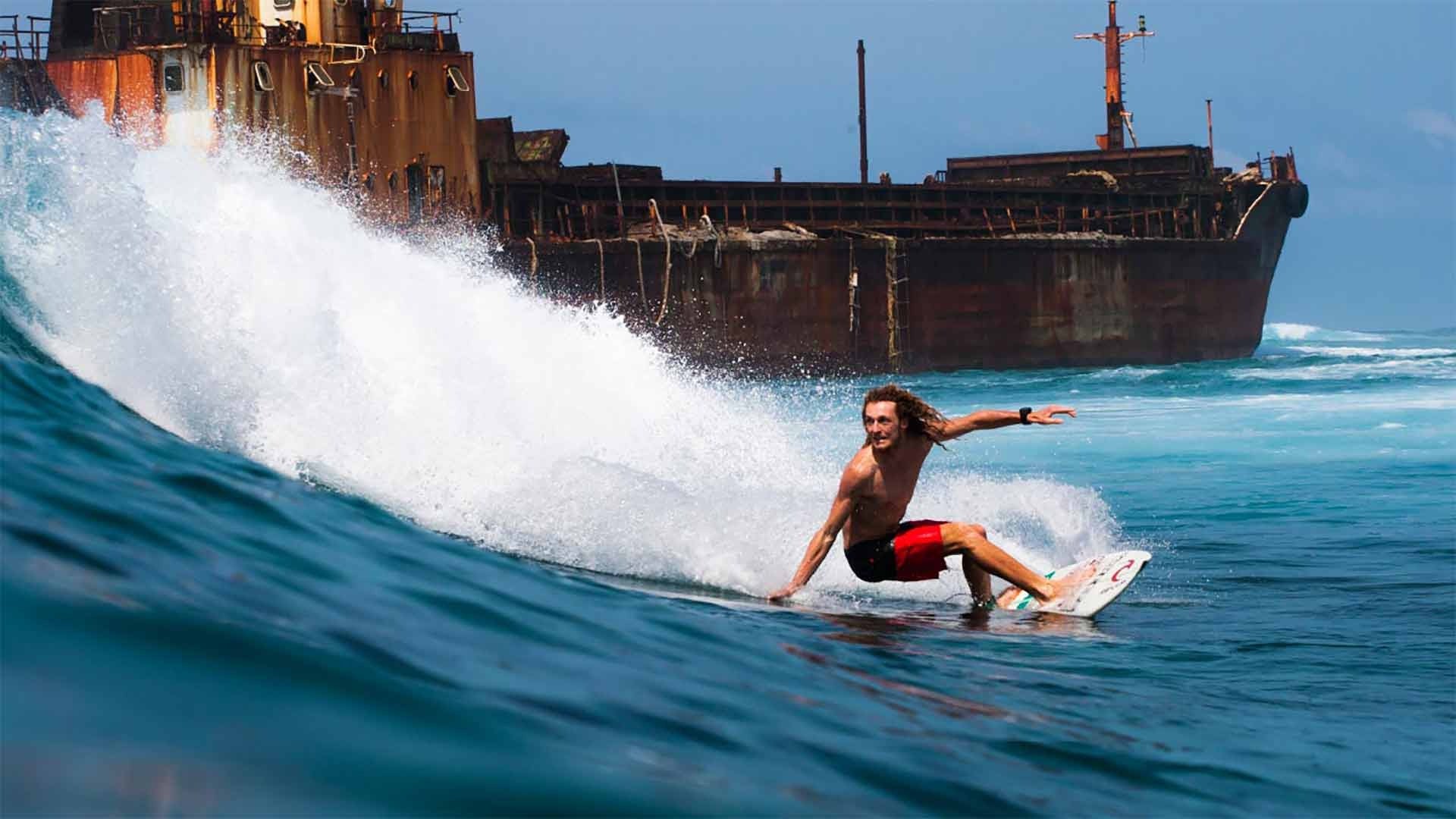 Louie surfing next to a ship