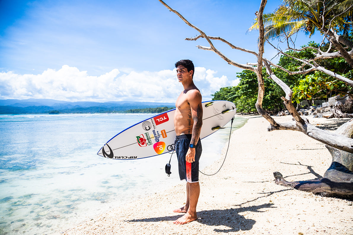 The surfer Gabriel Medina standing in front of the ocean