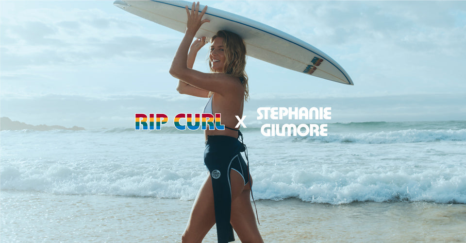 Woman holding a surfboard with 'RIP CURL x Stephanie Gilmore' text on a beach.