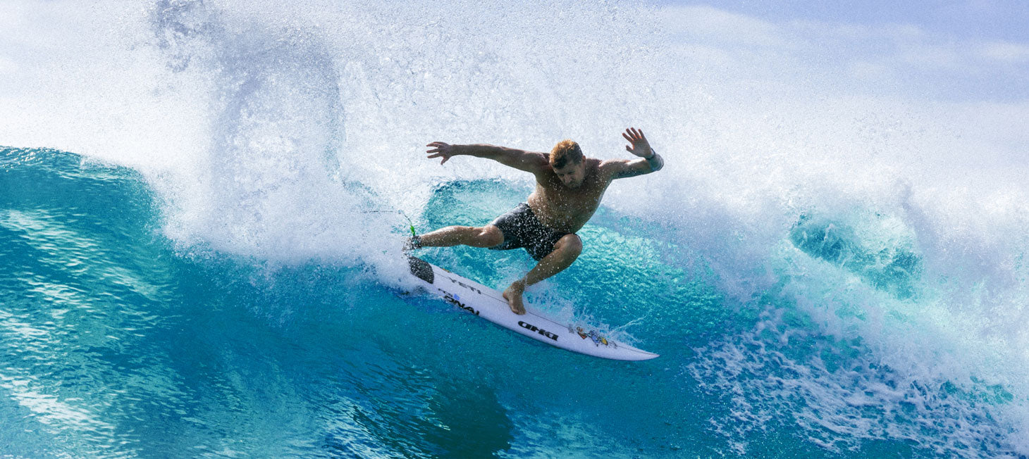 Mick Fanning surfing a wave on a clear blue day